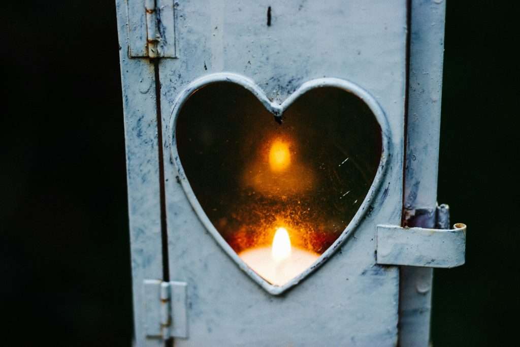 a candle in a heart shaped candle holder